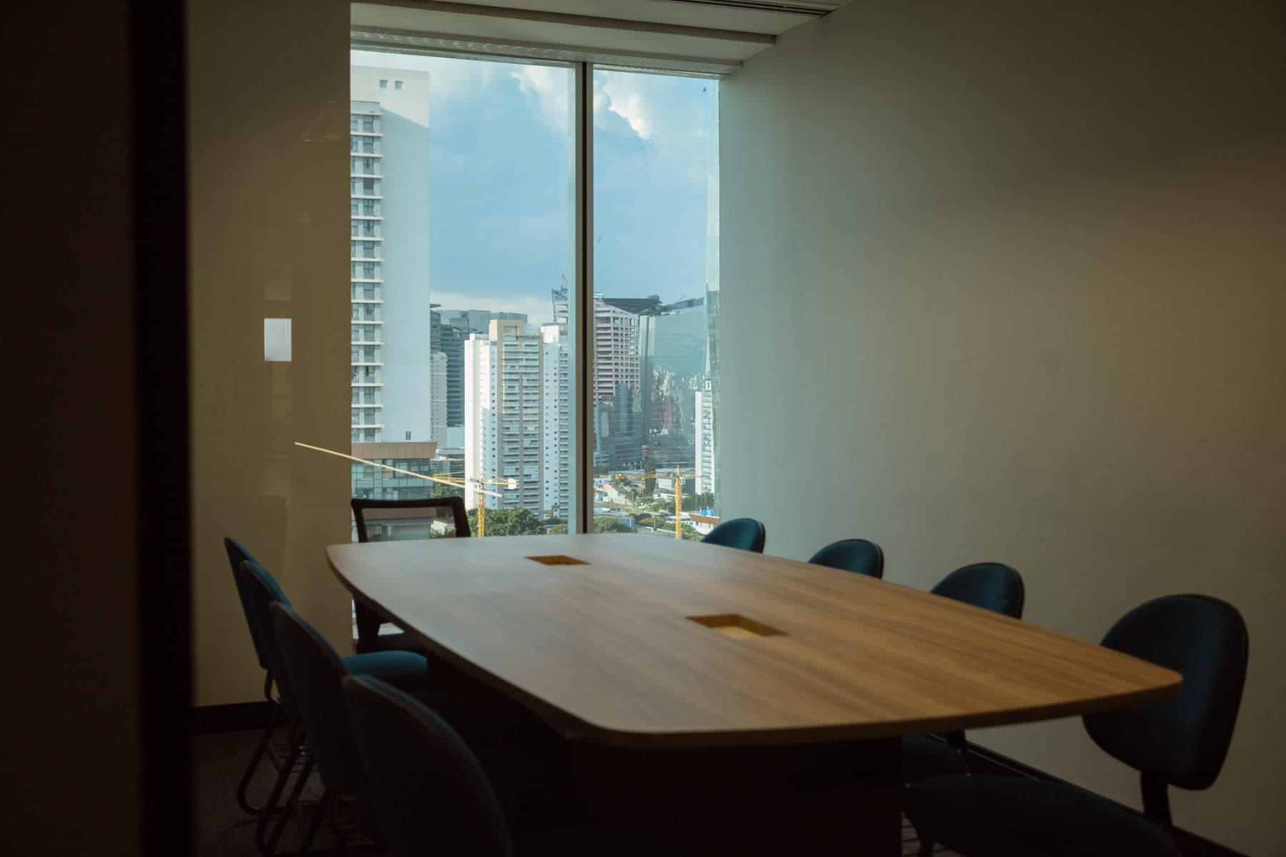 Sala de reunião do Sales Village com mesa redonda e vista para a cidade